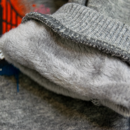 Close-up of a gray knit garment with a soft, fluffy light gray fleece lining folded over.